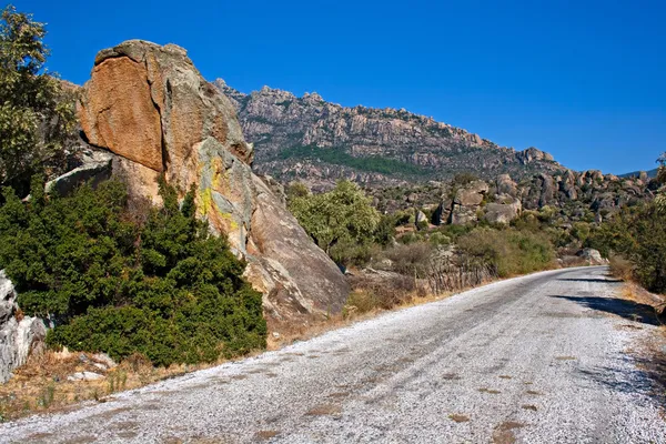 Roadway through unusual rock formations on mountain side — Stock Photo, Image