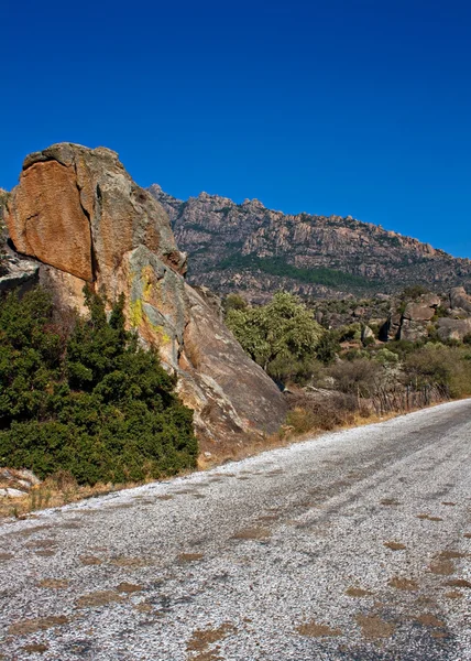 Roadway through unusual rock formations on mountain side — Stock Photo, Image