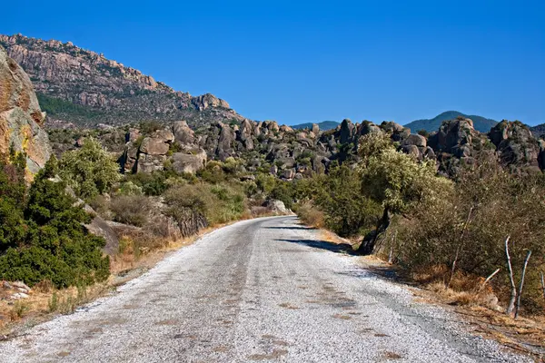 Roadway through unusual rock formations on mountain side — Stock Photo, Image