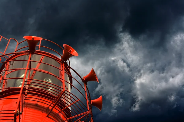 Barco de luz rojo con cuernos de niebla contra nubes de tormenta — Foto de Stock