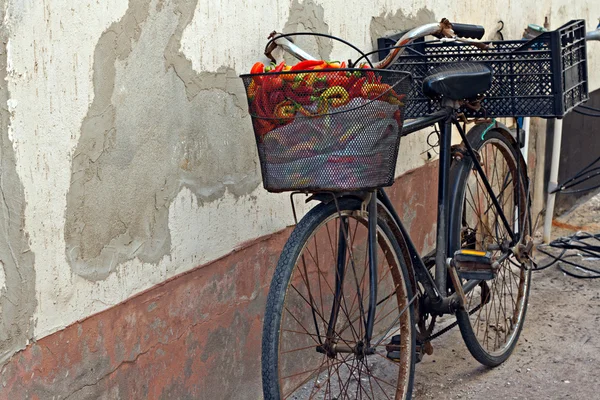 Vecchia bicicletta arrugginita con peperoni colorati nel cestino — Foto Stock