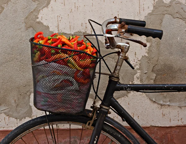 Старый ржавый велосипед с разноцветным перцем в корзине — стоковое фото