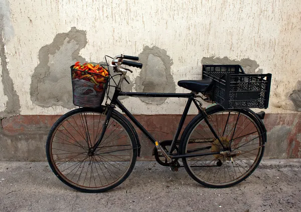 Vecchia bicicletta arrugginita con peperoni colorati nel cestino — Foto Stock