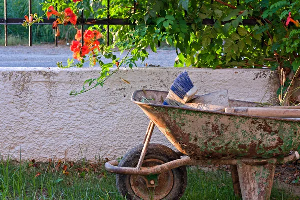 Herramientas de jardinería en una vieja carretilla oxidada —  Fotos de Stock