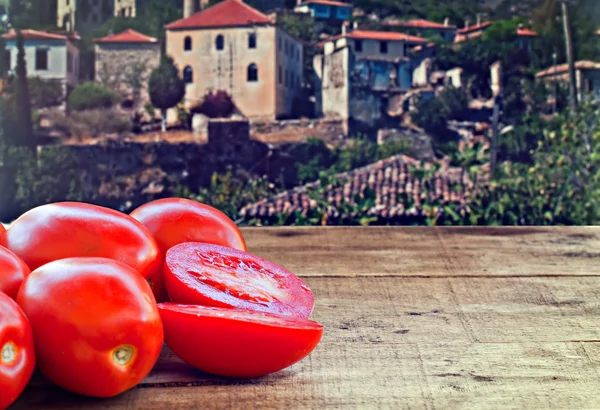 Tomates ciruela frescos sobre mesa de madera rústica con campo viejo —  Fotos de Stock