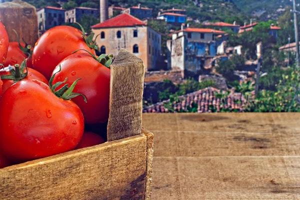 Caixa de tomates vermelhos maduros com fundo rural velho — Fotografia de Stock