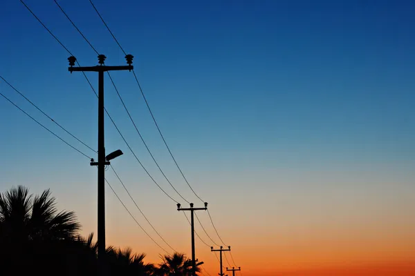 Elektrische hoogspanningslijnen tegen een dageraad hemel — Stockfoto