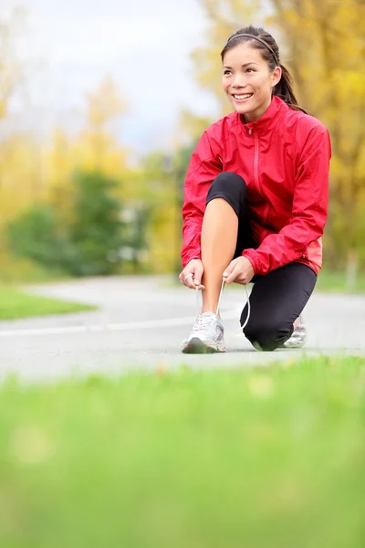 Corredor mujer atando zapatillas — Foto de Stock