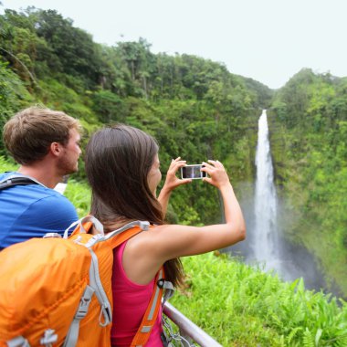 Tourist couple on Hawaii taking pictures clipart