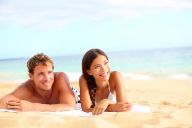 Couple on beach looking happy clipart
