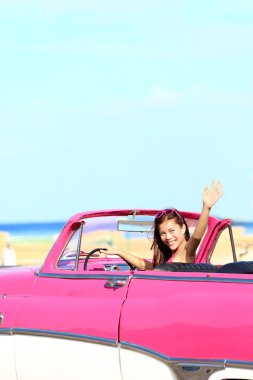 Woman driving convertible car waving happy clipart