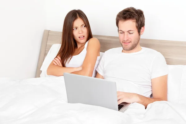 Met laptop in bed (echt) paar — Stockfoto
