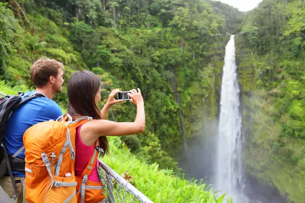 Pareja de turistas en Hawaii por cascada —  Fotos de Stock