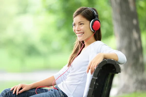 Mulher ouvindo música no parque — Fotografia de Stock