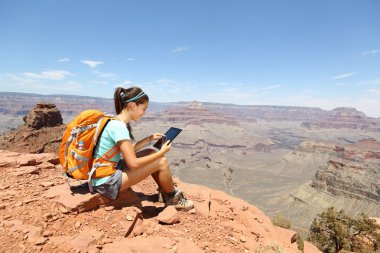 Tablet computer woman hiking in Grand Canyon clipart