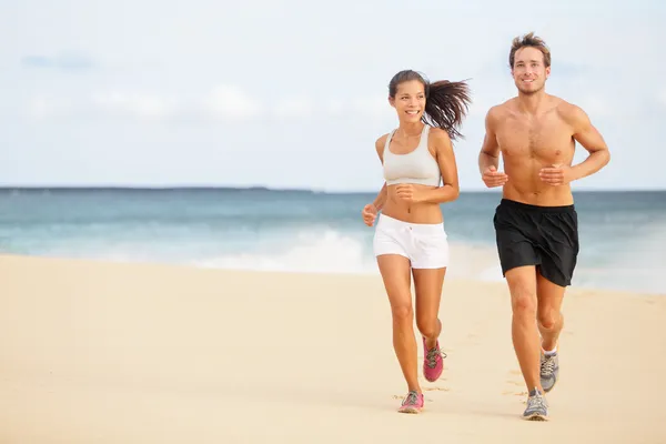 Läufer - junges Paar läuft am Strand — Stockfoto