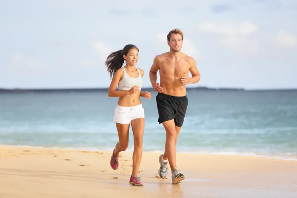 Corrida - jovem casal correndo na praia — Fotografia de Stock