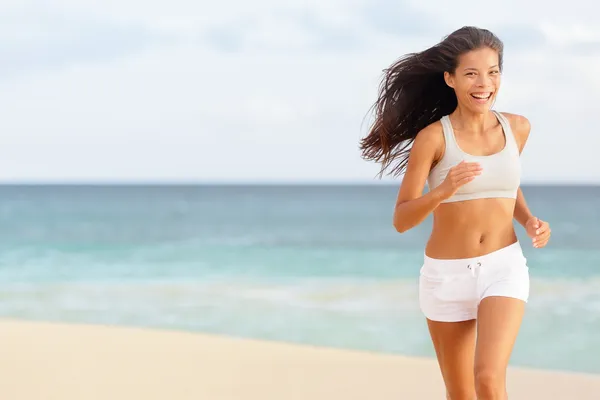 Donna corridore in esecuzione felice sulla spiaggia — Foto Stock