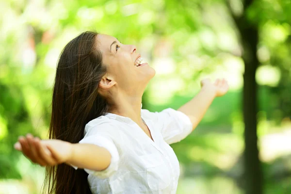 Junge Frau freut sich in einem Frühlings- oder Sommergarten — Stockfoto