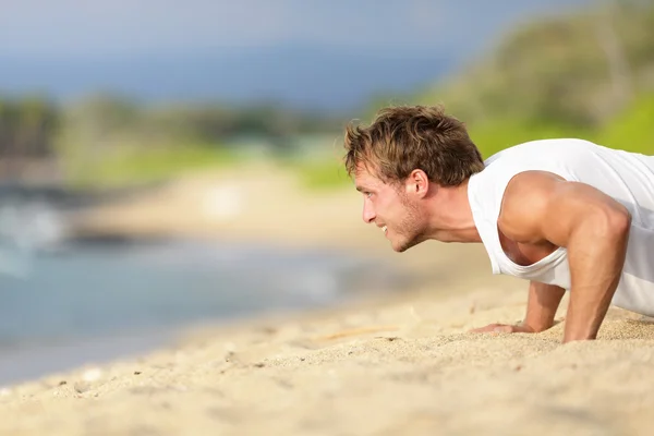 Push-ups - entrenamiento de hombre modelo de fitness en la playa —  Fotos de Stock