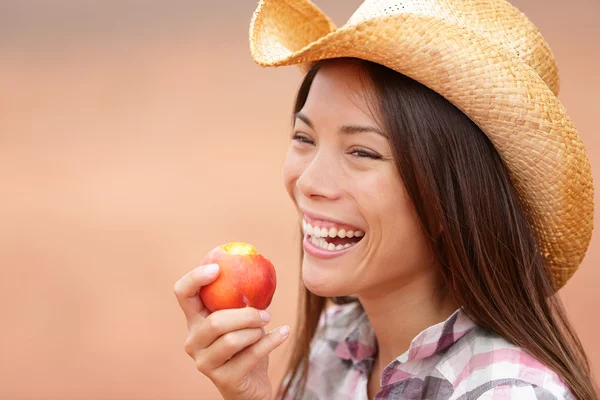 American cowgirl eating peach — Stock Photo, Image