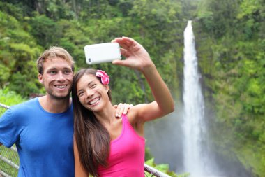 Couple tourists taking self portrait on Hawaii clipart