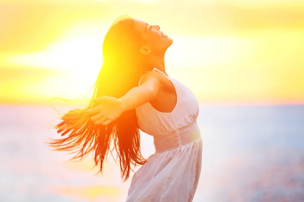 Freie glückliche Frau genießt Sonnenuntergang Stockbild