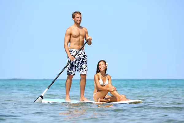 Spiaggia divertente coppia su stand up paddleboard — Foto Stock