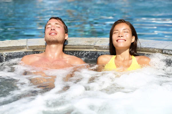 Spa casal relaxante desfrutando jacuzzi banheira de hidromassagem — Fotografia de Stock