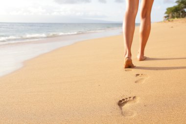 Beach travel - woman walking on sand beach closeup clipart