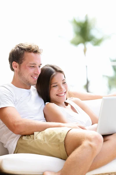 Par avkopplande tillsammans i soffan med laptop pc — Stockfoto