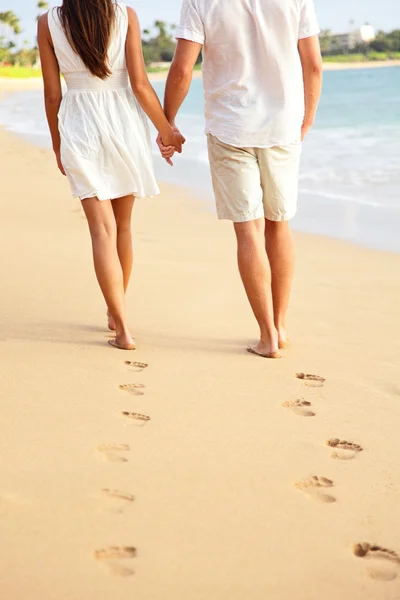 Paar hand in hand wandelen op het strand op vakantie — Stockfoto