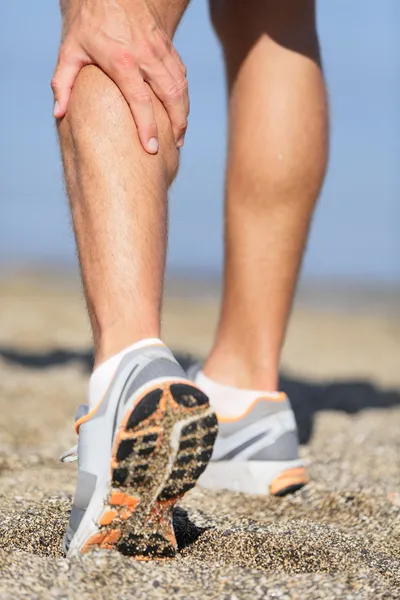 Sport injury - Man running clutching calf muscle — Stock Image Sport injury - Man running clutching calf muscle Royalty Free Stock Photos