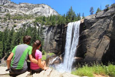 Hikers couple resting in Yosemite park - waterfall clipart