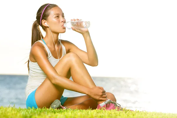 Фитнес-женщина пьет воду после тренировки на улице — стоковое фото