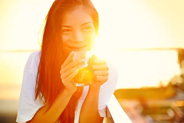 Aziatische vrouw drinken koffie in de zon — Stockfoto