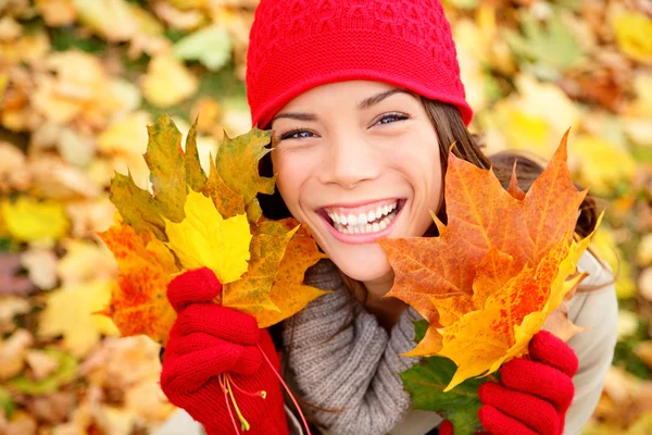 Mulher de outono segurando folhas de outono na floresta — Fotografia de Stock