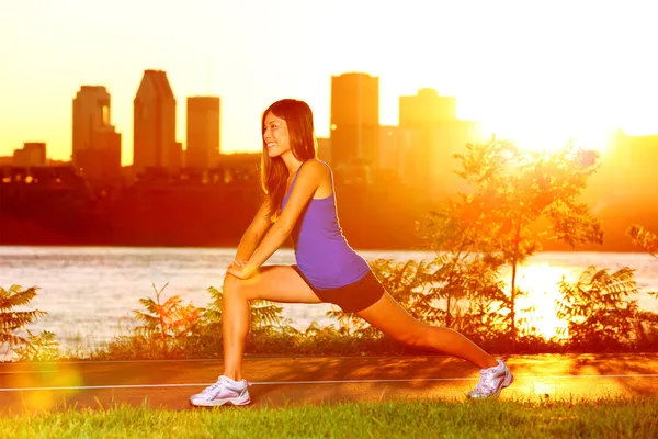 Kadın atlet çalıştırdıktan sonra bacak germe — Stockfoto