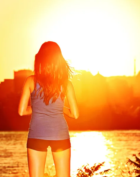 Женщина наслаждается закатом солнца после бега — стоковое фото