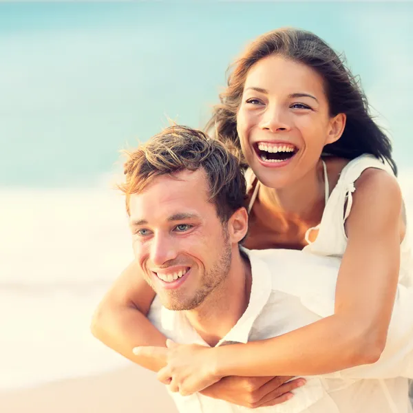 Love - gelukkige paar op strand plezier meeliften — Stockfoto