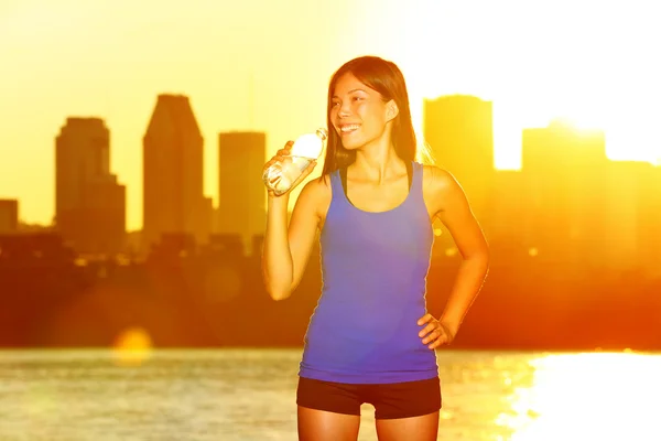 Fitness runner drinking water after city running — Stockfoto