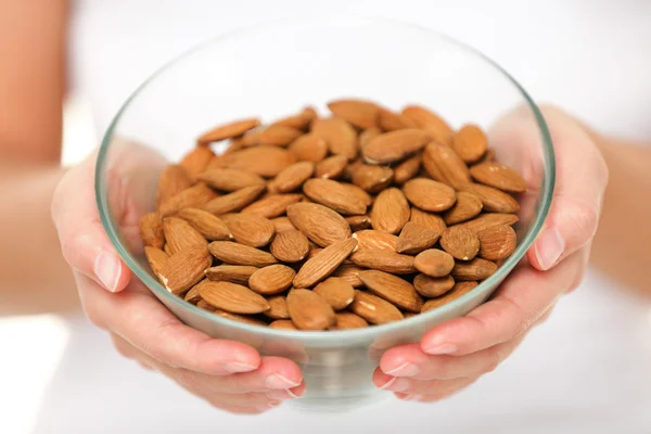 Almonds - woman showing raw almond bowl — Stock Photo, Image