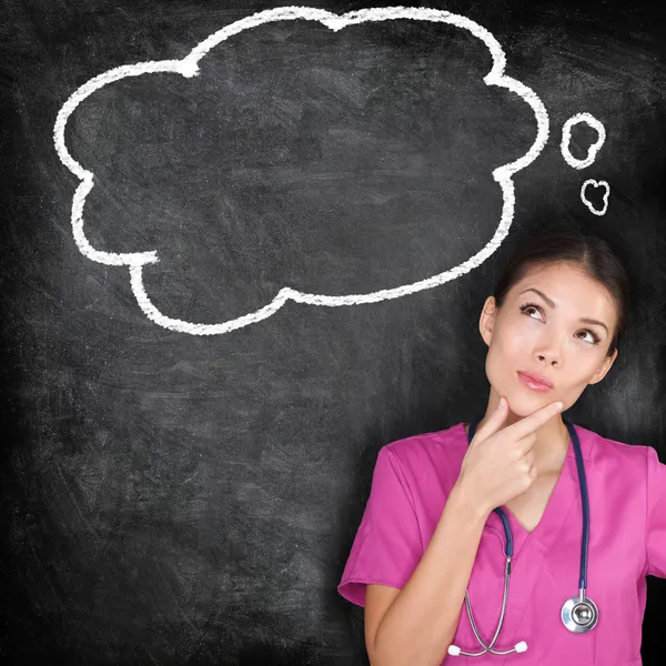 Medical concept - thinking nurse doctor blackboard — Stock Photo, Image