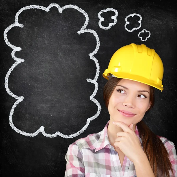 Thinking construction worker girl on chalkboard — Stock Photo, Image