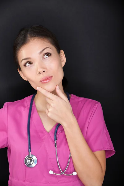 Läkare, medicinska kvinnlig sjuksköterska tänker titta upp — Stockfoto