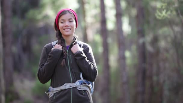 Mulher caminhando olhando para o lado durante a caminhada na floresta — Vídeo de Stock