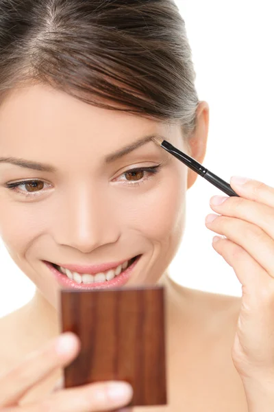 Maquillaje chica poniendo color de la ceja en el espejo — Foto de Stock