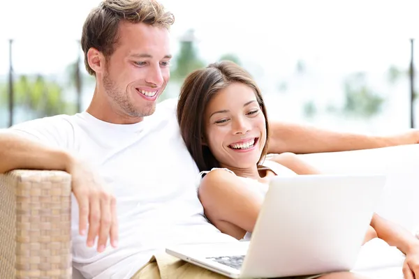 Para w kanapie z laptopa pc w domu śmiech — Zdjęcie stockowe