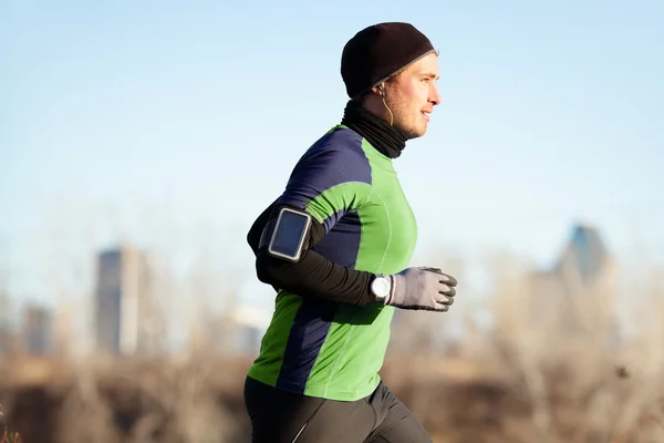 Correre uomo jogging in autunno alla musica al telefono — Foto Stock