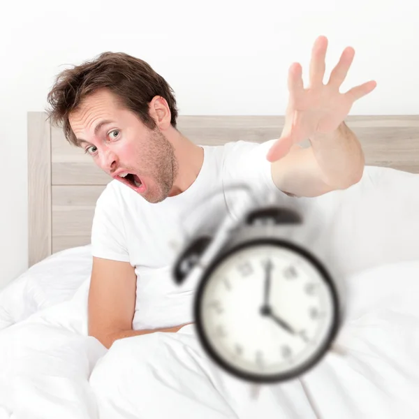 El hombre se despierta tarde para el trabajo temprano lanzando la alarma Imagen de stock